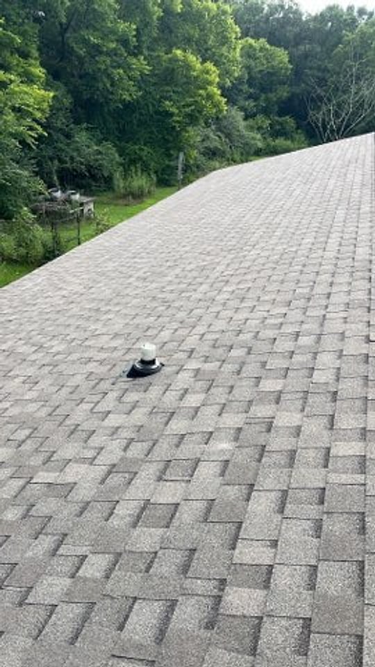 Close-up of a pipe boot flashed into new architectural shingles
